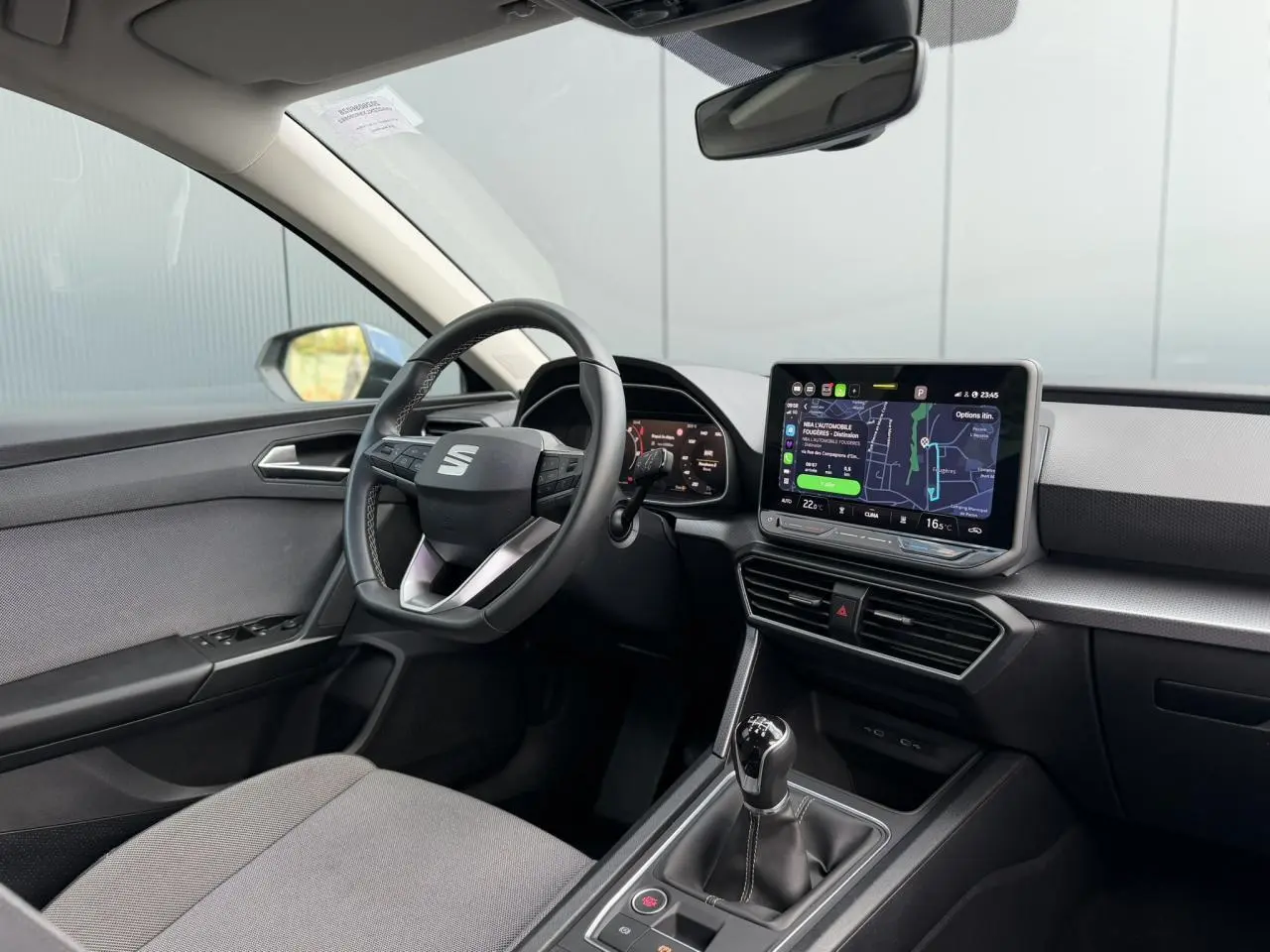 Vue intérieure côté conducteur du SEAT Leon ST 2025, montrant le volant cuir multifonction et l’écran tactile 10,4 pouces.
