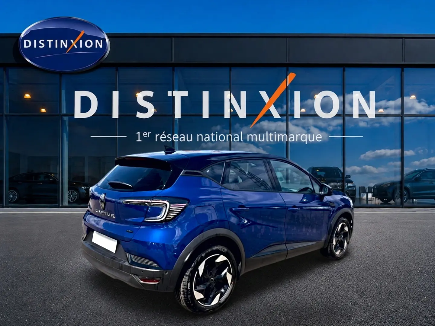 Vue 3/4 arrière droite d’un Renault Captur 2026 bleu iron avec toit noir, jantes alu et feux arrière LED distinctifs.