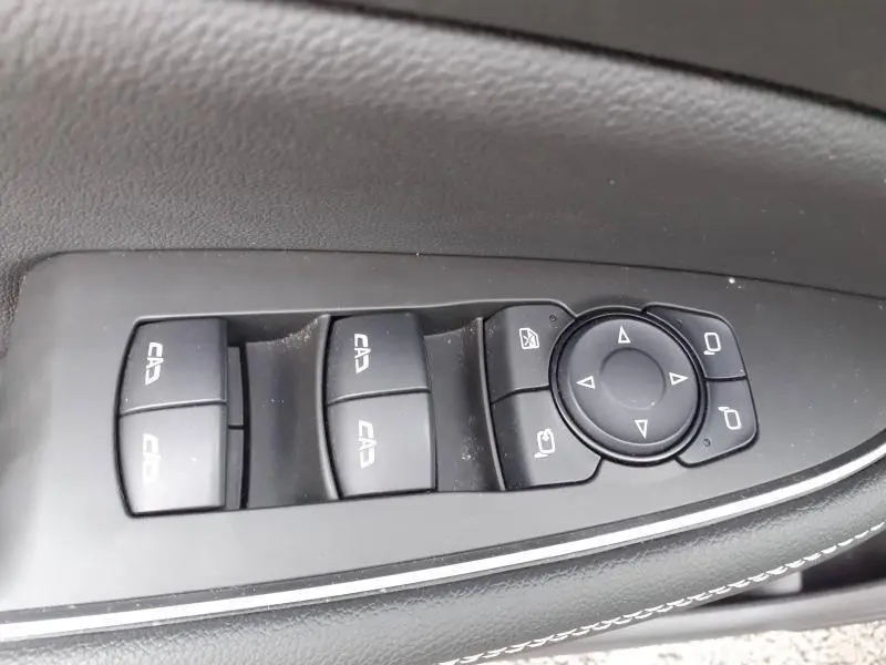 Commandes électriques des vitres et rétroviseurs sur la porte côté conducteur d'une Opel Insignia Grand Sport blanc glacier 2021.