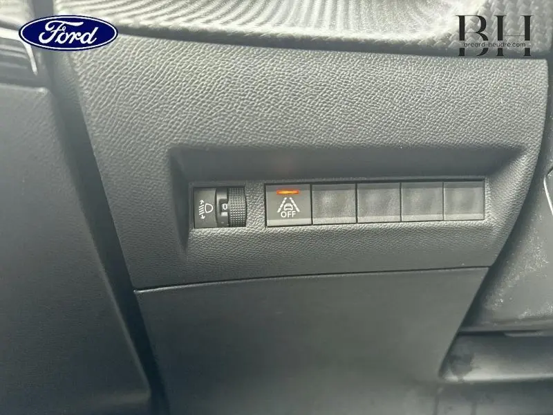 Image ne correspondant pas au véhicule Peugeot 2008, montrant un panneau de commandes intérieures en plastique noir avec boutons et molette.