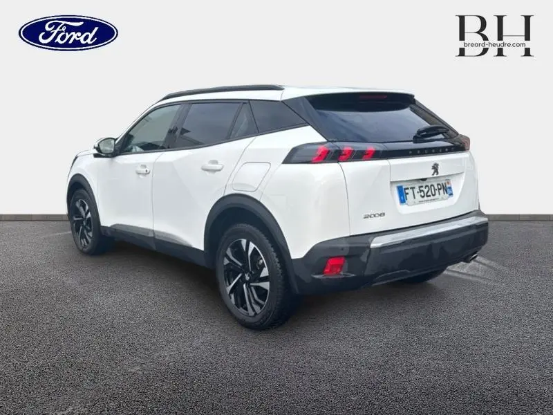 Vue 3/4 arrière droite d'un Peugeot 2008 blanc banquise avec jantes alu et feux arrière LED distinctifs.