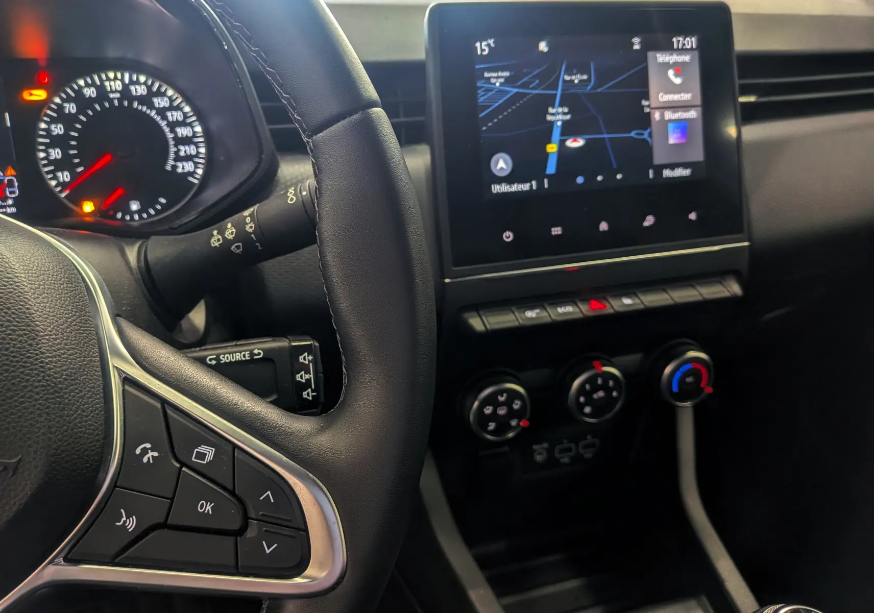 Vue intérieure côté gauche du tableau de bord de la Renault Clio V gris platine, avec écran tactile et volant multifonction.