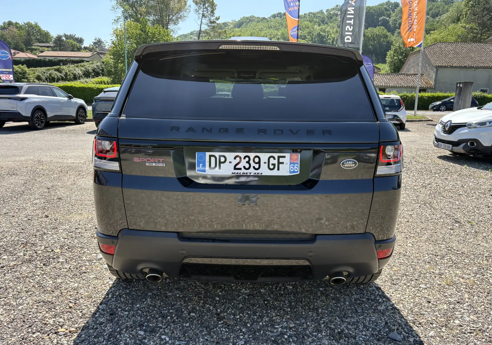 Vue arrière d'un Range Rover Sport noir 2015 avec plaques françaises, feux arrière LED et double sortie d'échappement visible.