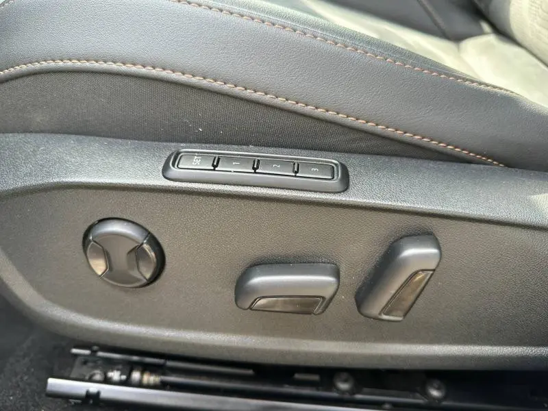 Détail des commandes de réglage électrique du siège avant en cuir noir avec surpiqûres marron du CUPRA Formentor 1.5 eTSI Hybrid 2025.