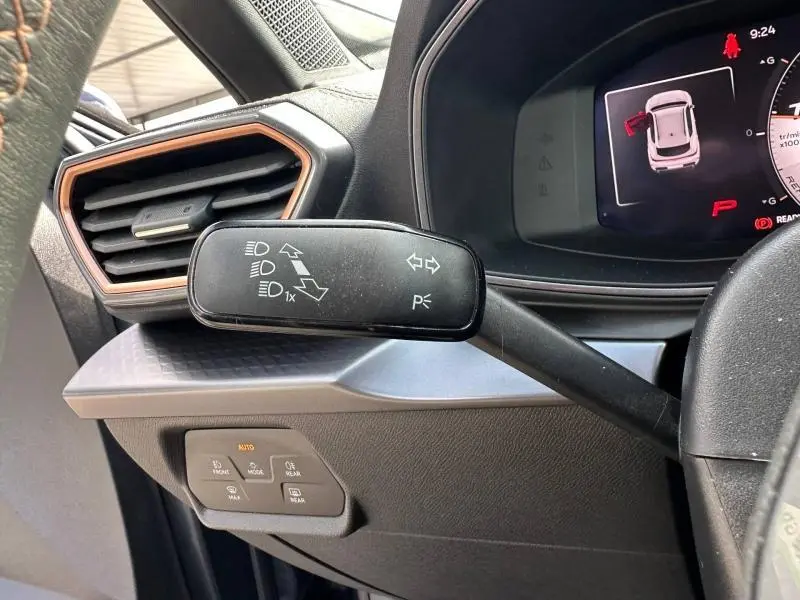 Gros plan sur la commande des clignotants à gauche du volant dans l’habitacle gris et noir du CUPRA Formentor 2025.