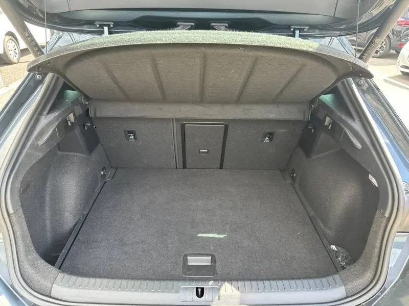 Vue intérieure du coffre ouvert d'une CUPRA Formentor gris Magnétique métallisé, montrant un espace de rangement propre et spacieux.