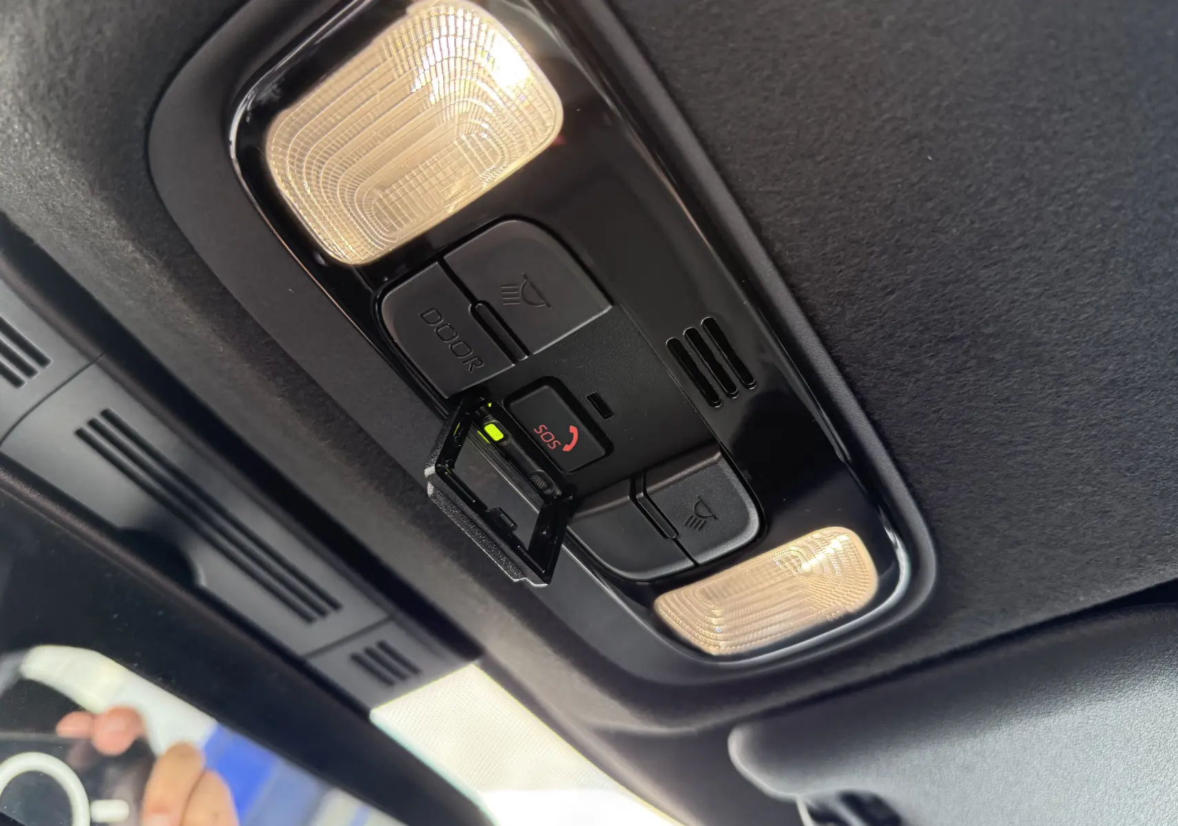 Détail du plafonnier intérieur noir avec éclairages et bouton SOS activé dans une Toyota Yaris Cross blanche 2024.
