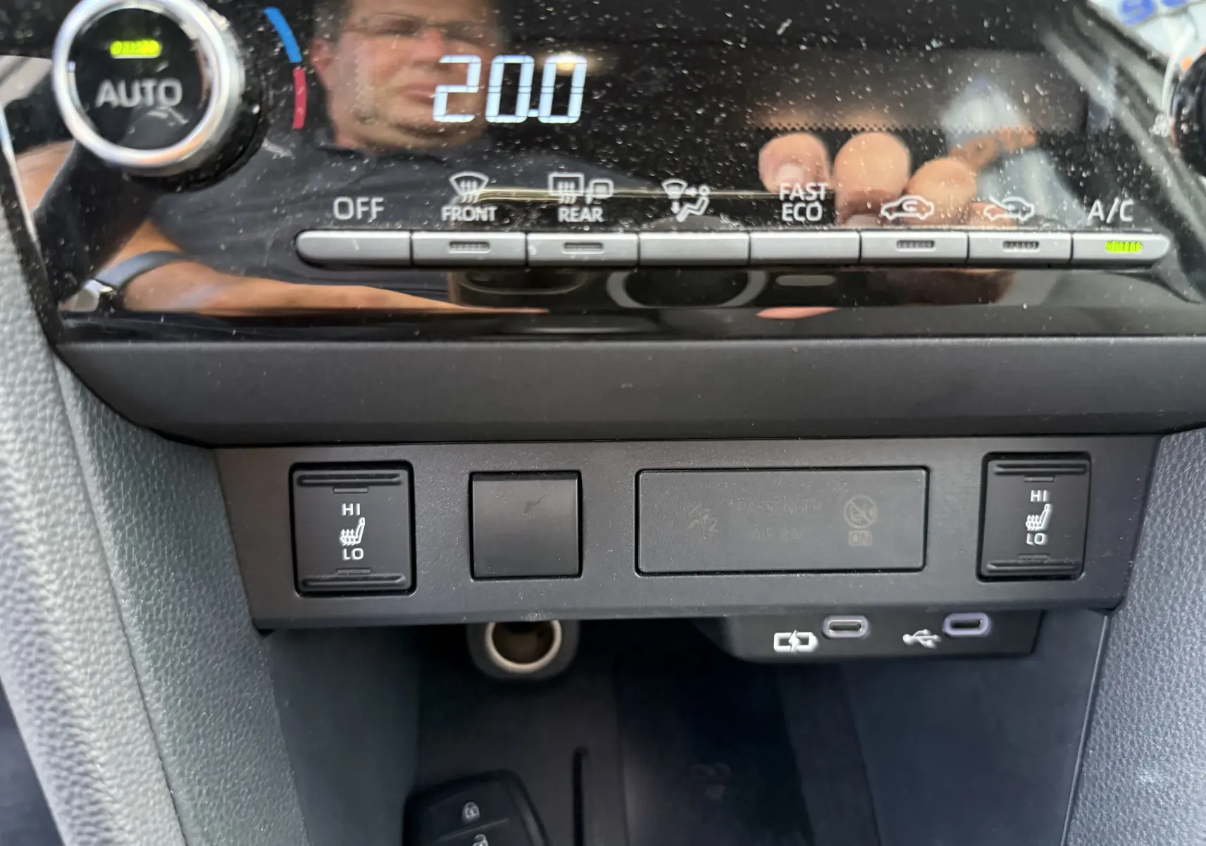 Détail du tableau de bord de la Toyota Yaris Cross 130 CH Design 2024, montrant les commandes de climatisation et sièges chauffants.