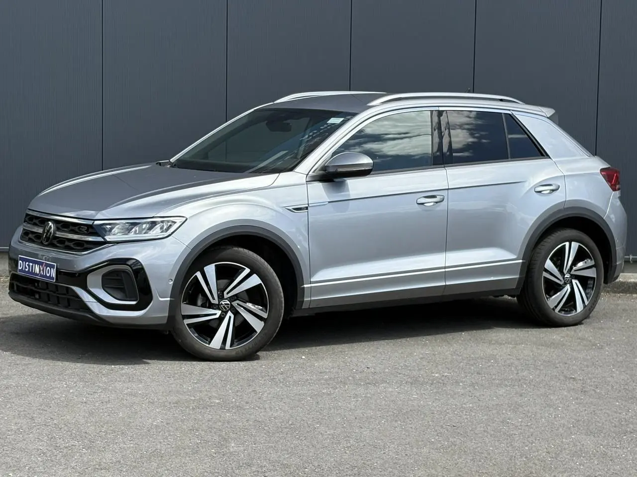 Volkswagen T-Roc 1.5 TSI R-Line gris pyrite en profil droit, avec jantes alliage 18 pouces Nevada et calandre R-Line.