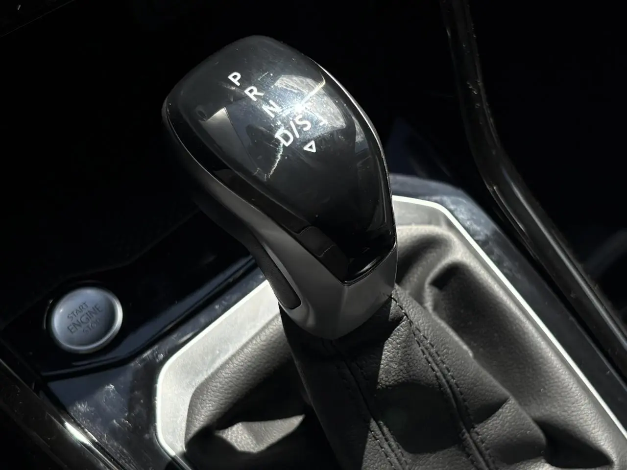 Gros plan sur le levier de vitesse automatique noir et argenté du Volkswagen T-Roc 2025, bouton start visible à gauche.