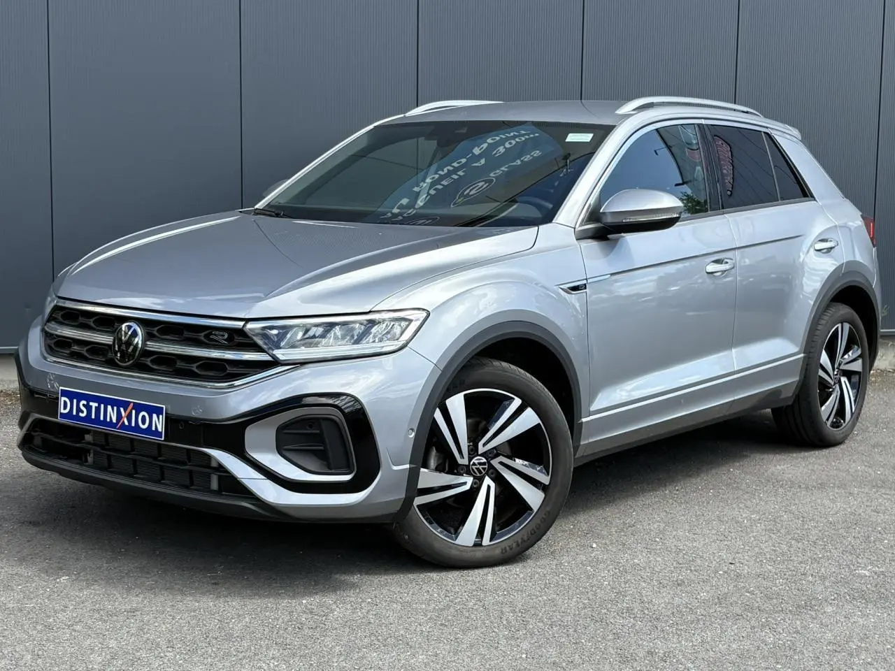 Volkswagen T-Roc 1.5 TSI R-Line gris pyrite en 3/4 avant droit avec jantes alliage 18 pouces Nevada et calandre R-Line.