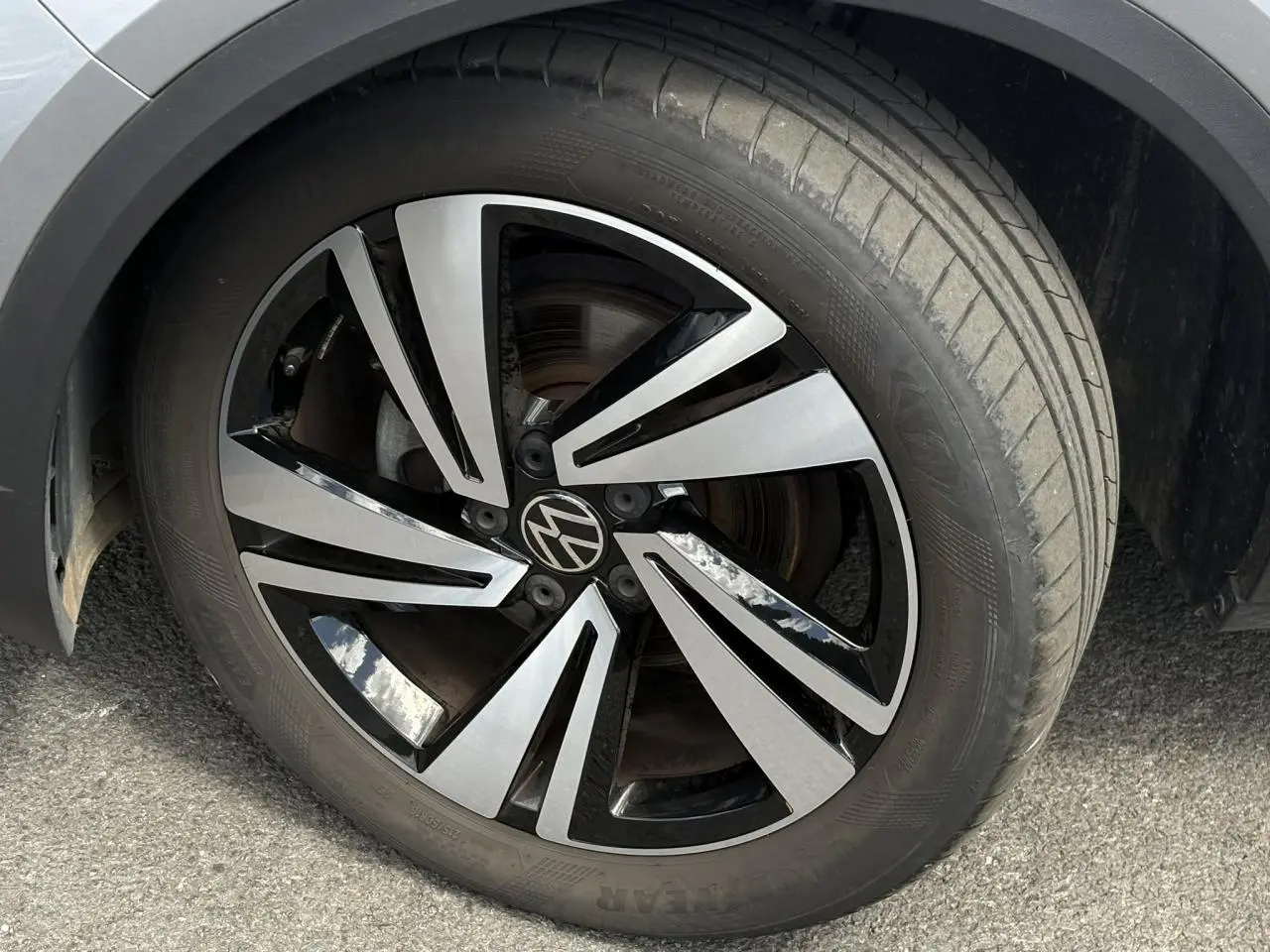Gros plan sur la jante alliage 18 pouces Nevada bicolore noir et argent du Volkswagen T-Roc gris pyrite.