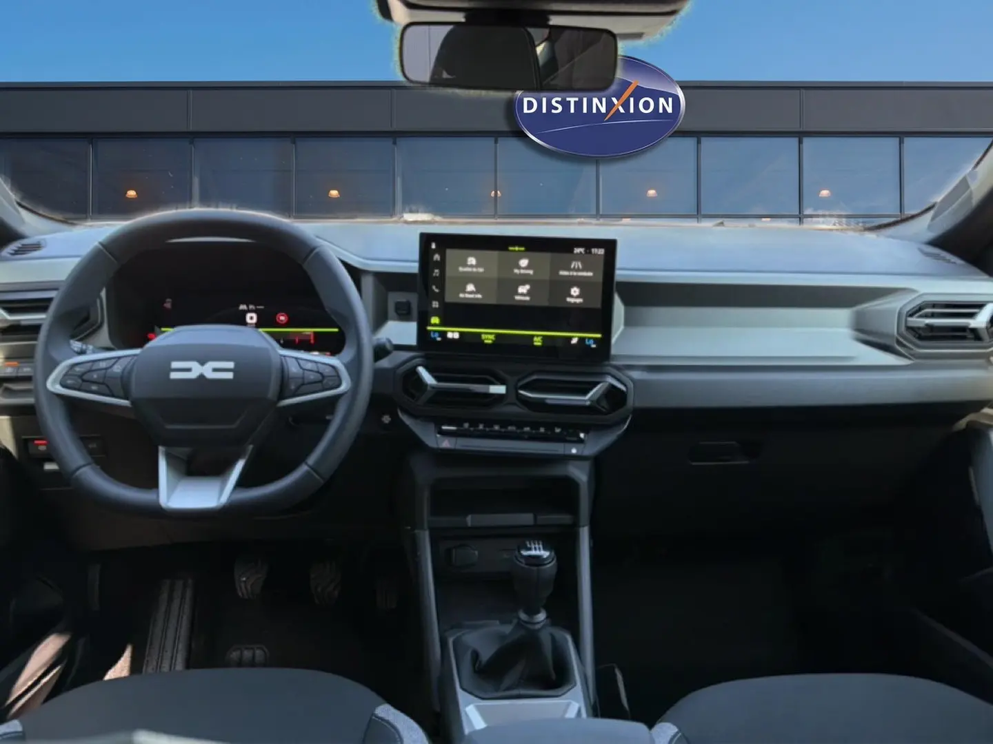 Vue intérieure avant du tableau de bord du Dacia Bigster blanc 2026 avec volant multifonction et écran tactile central.