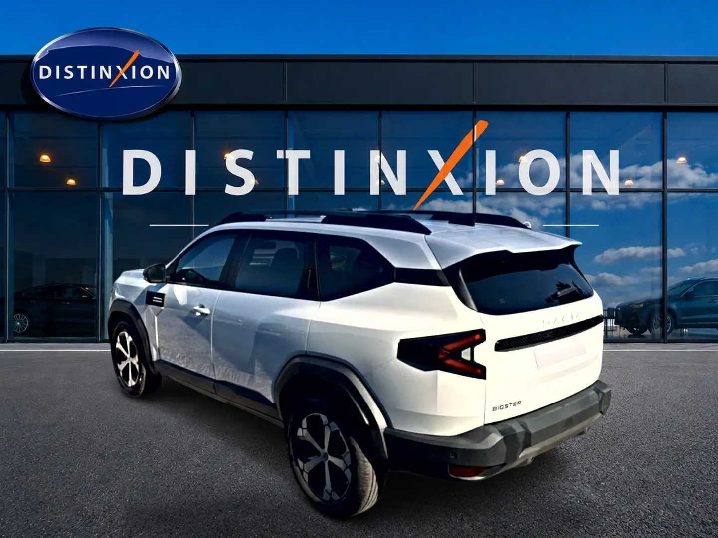 Vue 3/4 arrière droite du Dacia Bigster blanc 2026 avec barres de toit et feux arrière LED distinctifs.