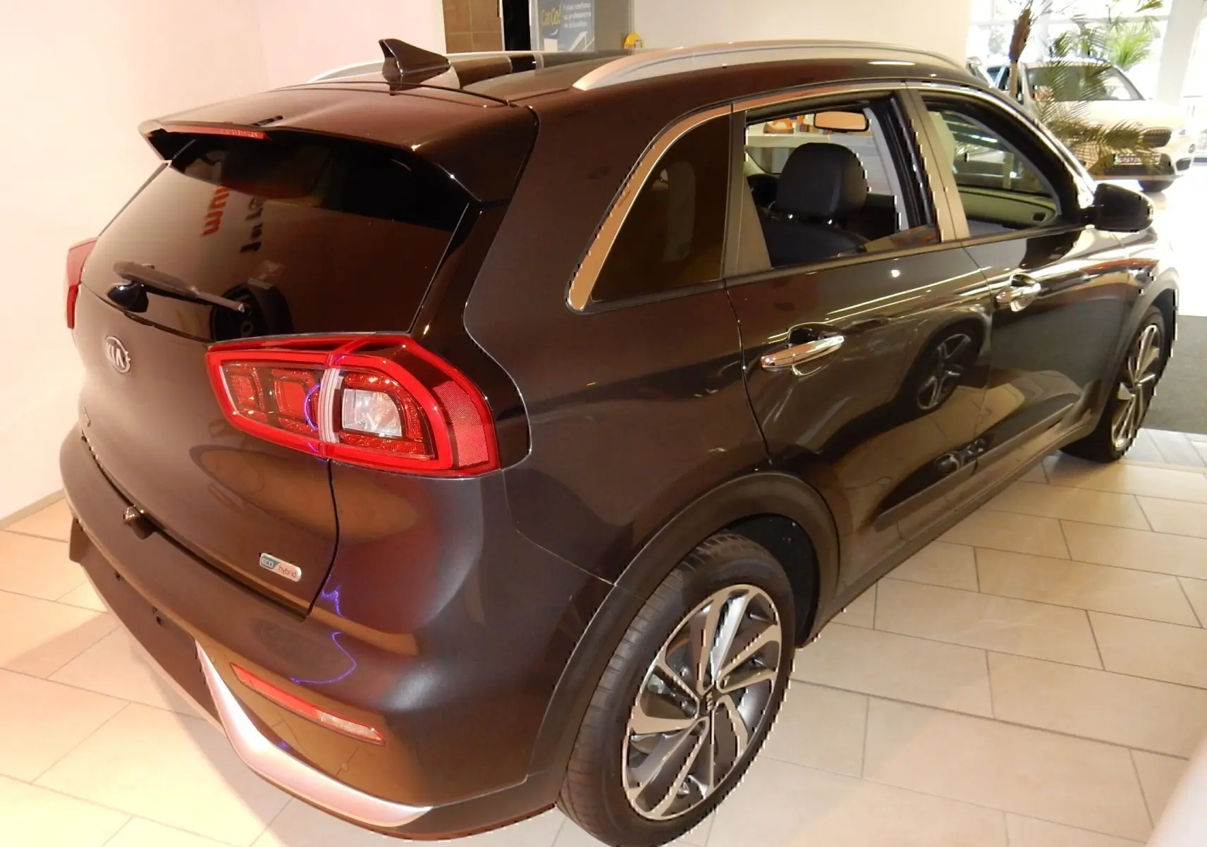 Vue 3/4 arrière droite d’un KIA Niro hybride gris galène métallisé avec jantes alliage et vitres teintées.