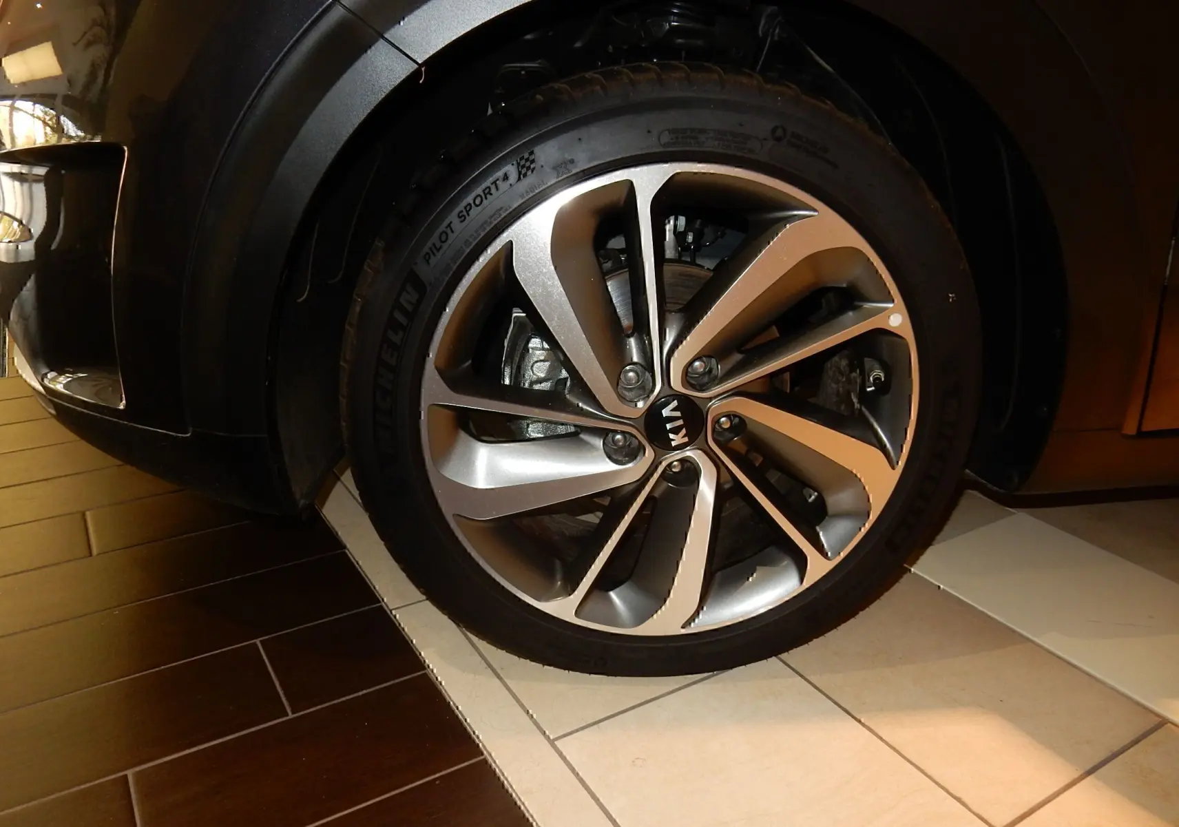 Gros plan sur la roue avant gauche avec jante alliage bicolore du KIA Niro gris galène métal.