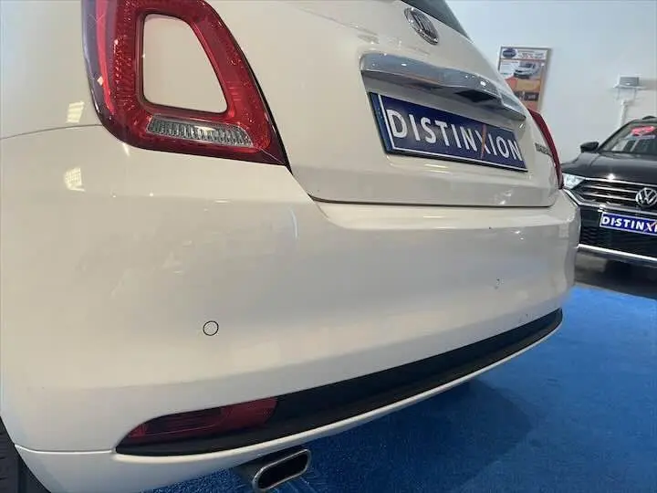 Vue rapprochée arrière droite d'une FIAT 500 blanche 2023 avec feu arrière distinctif et plaque Distinxion.