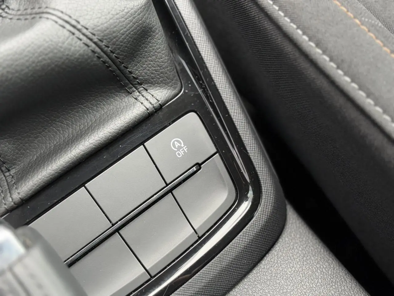 Gros plan sur les boutons de commande près du levier de vitesse en cuir dans la Skoda Scala TSI 110 DSG Ambition 2024.