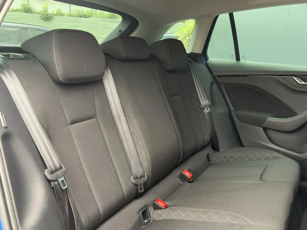 Vue intérieure côté droit des sièges arrière noirs de la SKODA SCALA TSI 110 DSG Ambition 2024 en Bleu Energy.