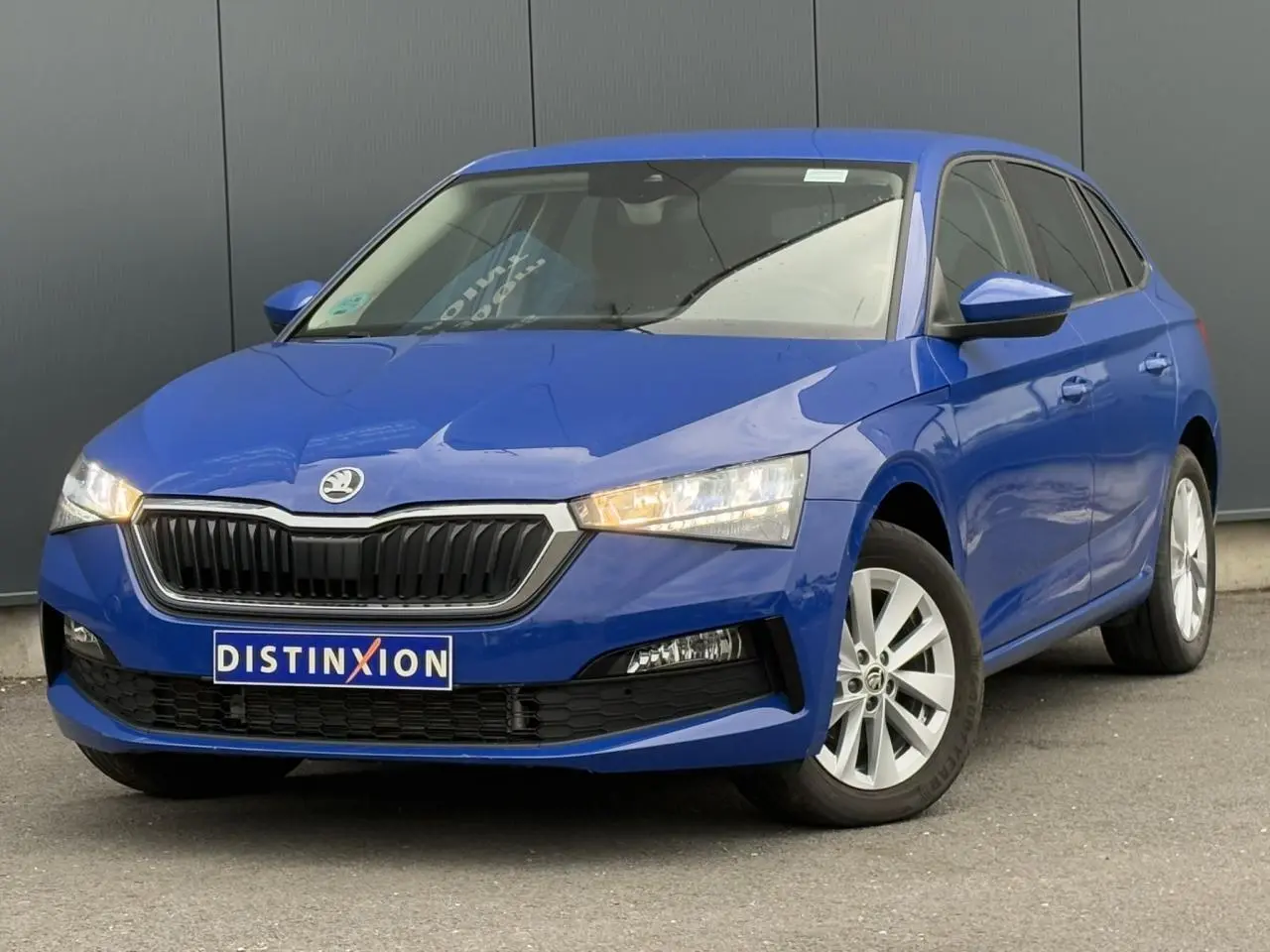 Vue 3/4 avant droite d'une Skoda Scala bleu Energy avec calandre noire et jantes alliage argentées.