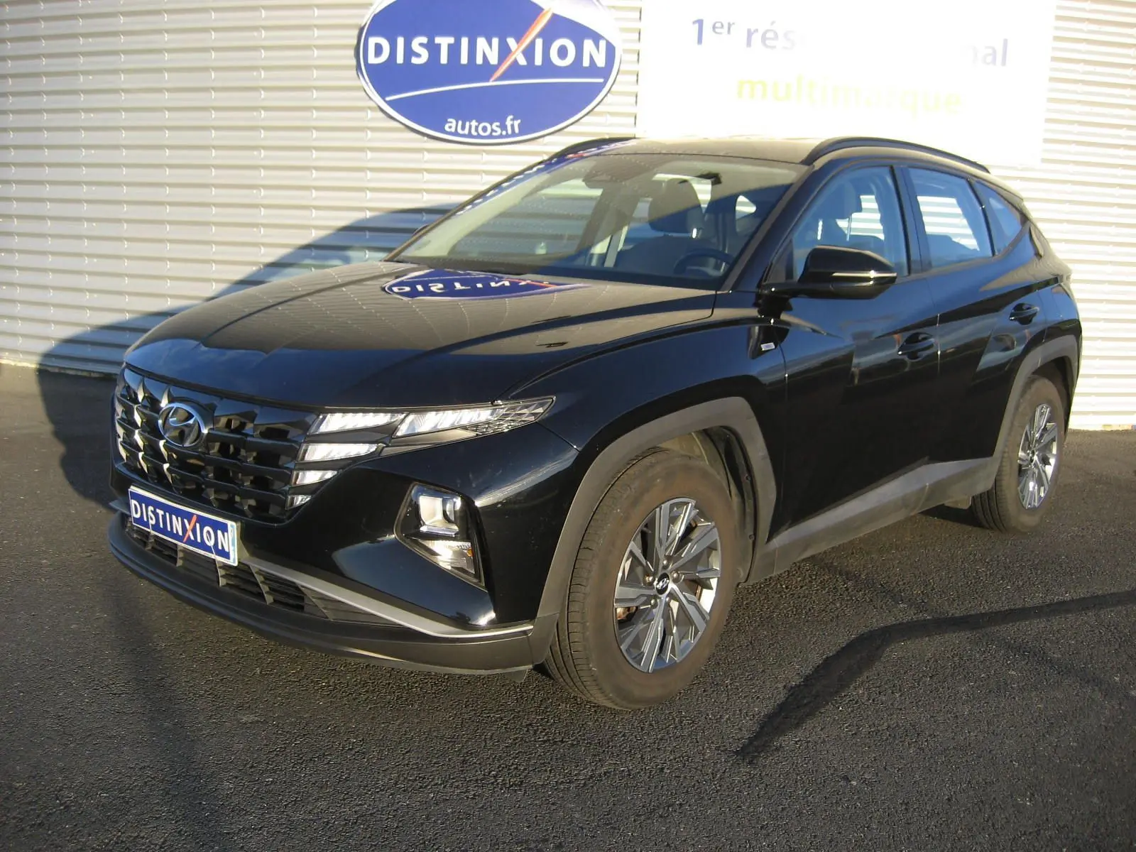 Hyundai Tucson noir 2022 en 3/4 avant droit, avec calandre distinctive et jantes alliage visibles.