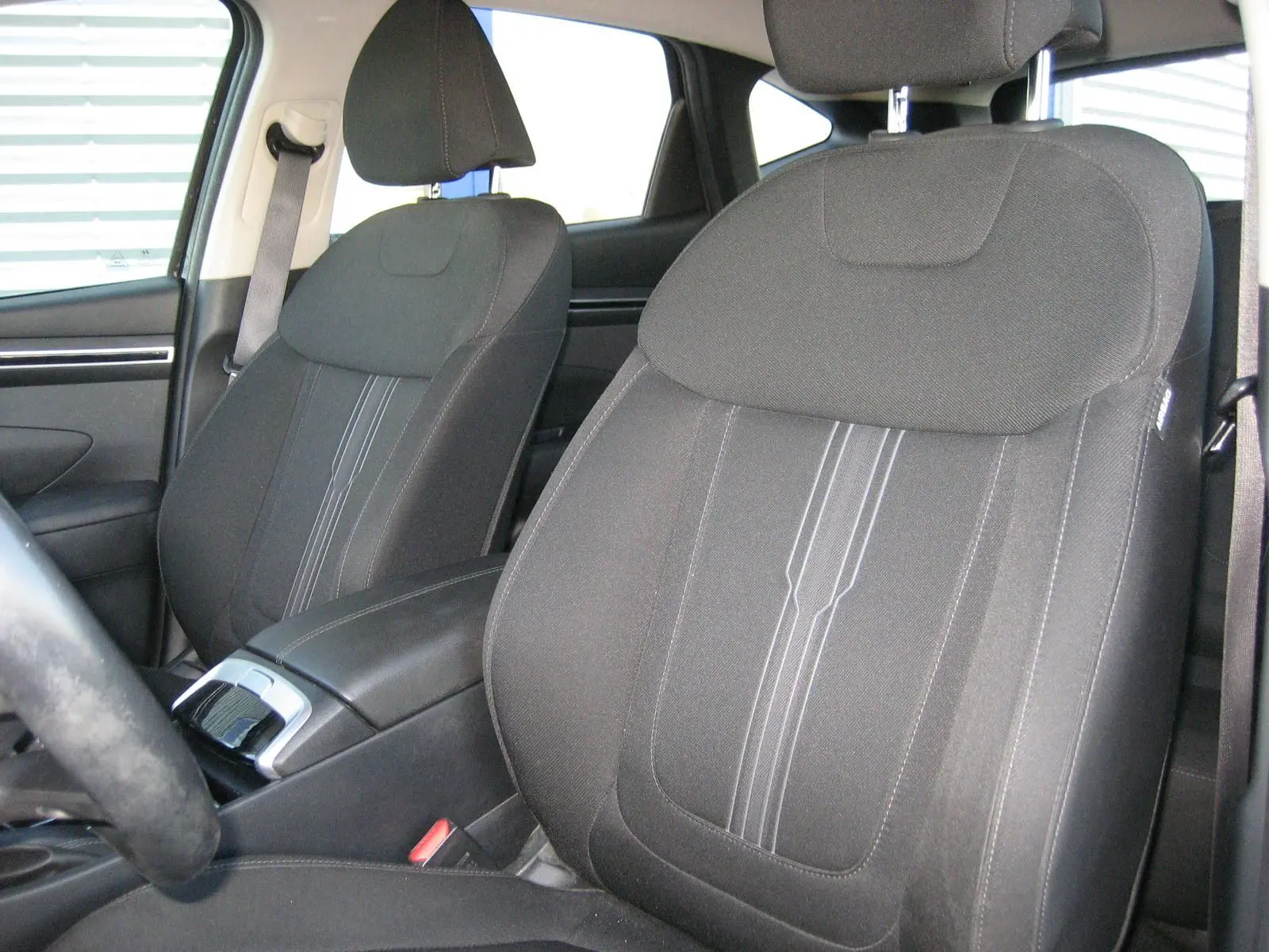 Vue rapprochée des sièges avant noirs du Hyundai Tucson 2022, mettant en valeur leur tissu et coutures centrales.