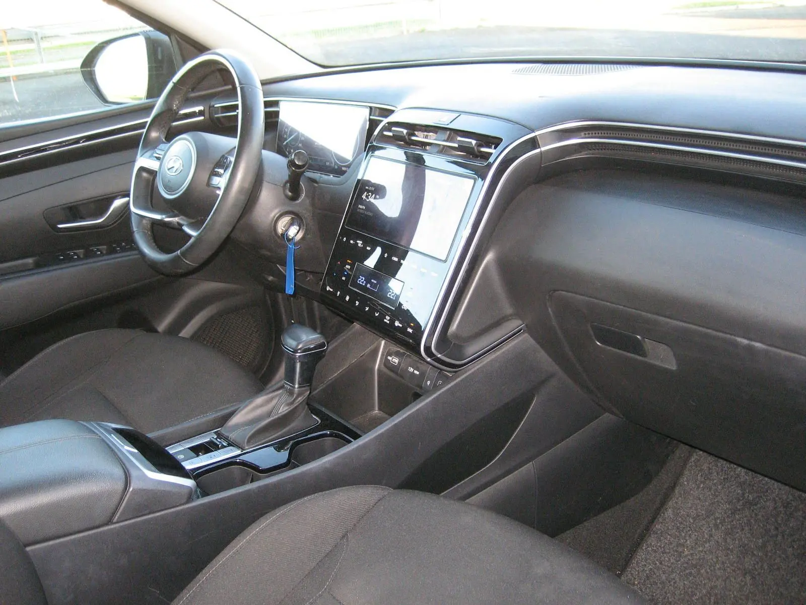 Intérieur noir du Hyundai Tucson 2022, vue côté conducteur sur le tableau de bord et la console centrale avec écran tactile.