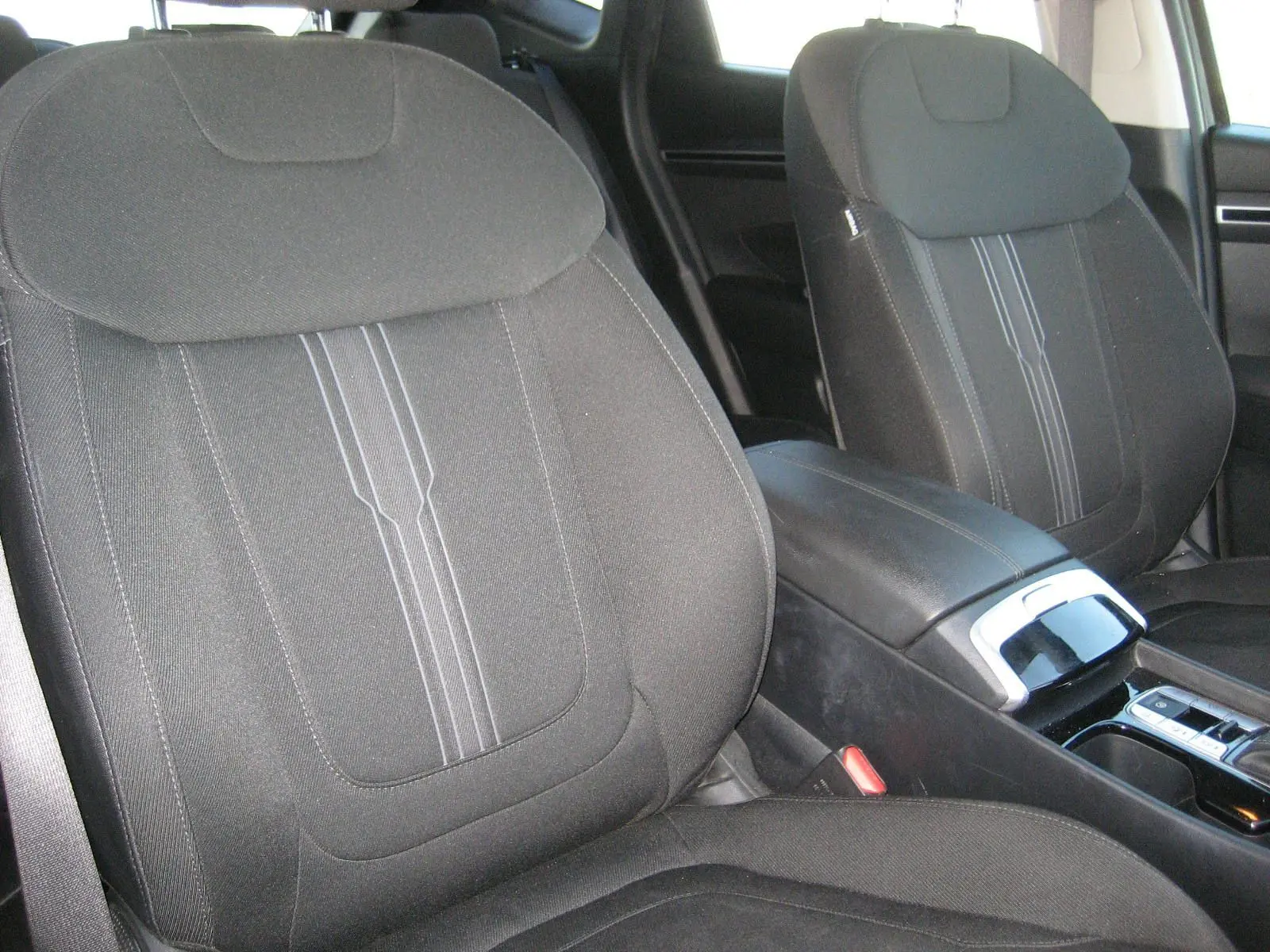 Gros plan sur les sièges avant noirs et la console centrale du Hyundai Tucson III hybride diesel 2022, vue côté droit.