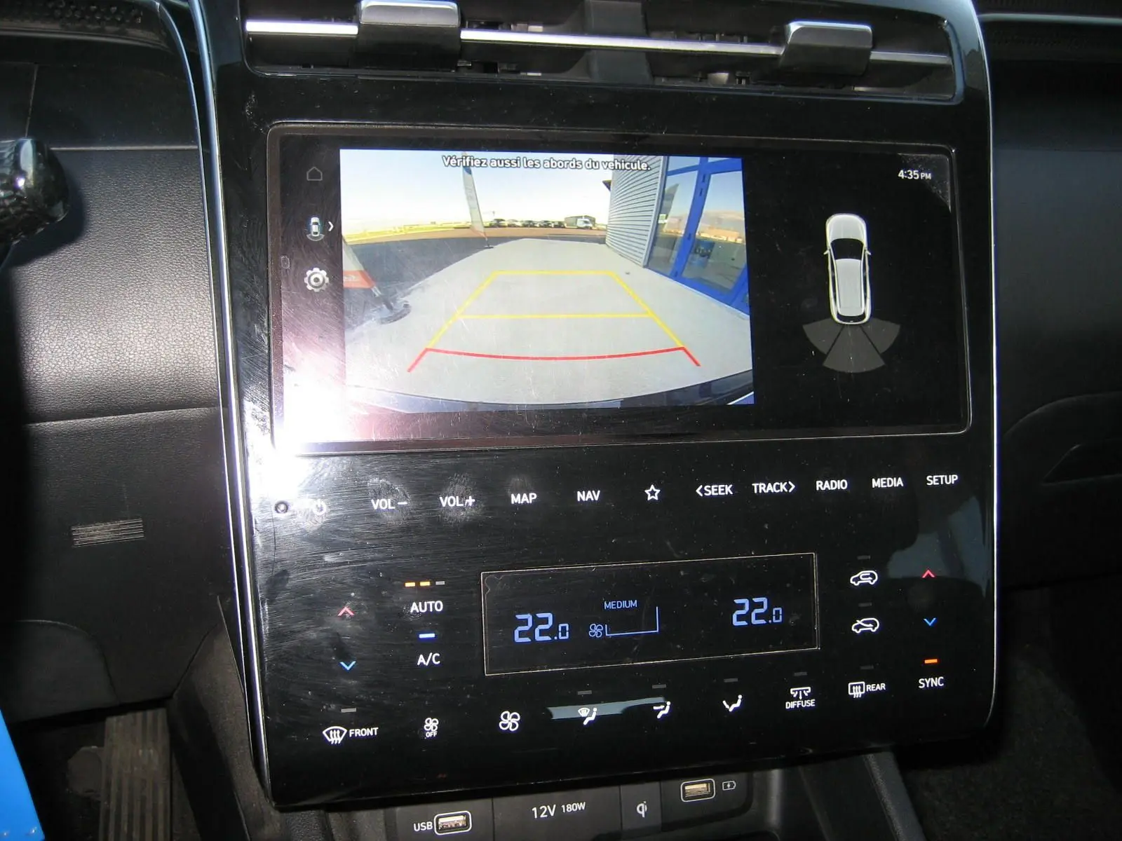 Écran tactile central du Hyundai Tucson noir 2022 montrant la caméra de recul et les commandes de climatisation.