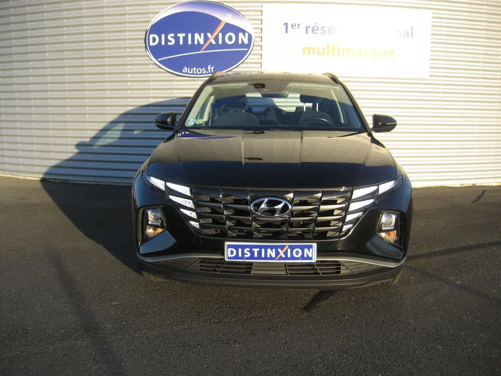 Vue frontale d'un Hyundai Tucson noir 2022 avec calandre large et feux LED distinctifs allumés.