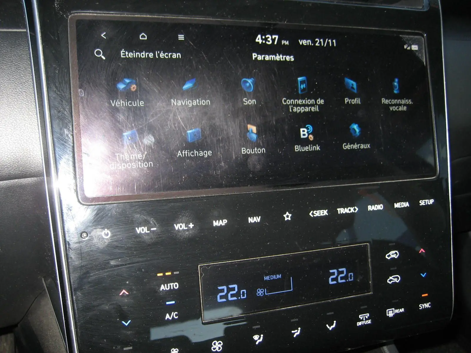 Écran tactile central du tableau de bord du Hyundai Tucson noir 2022, affichant les réglages de climatisation et de navigation.