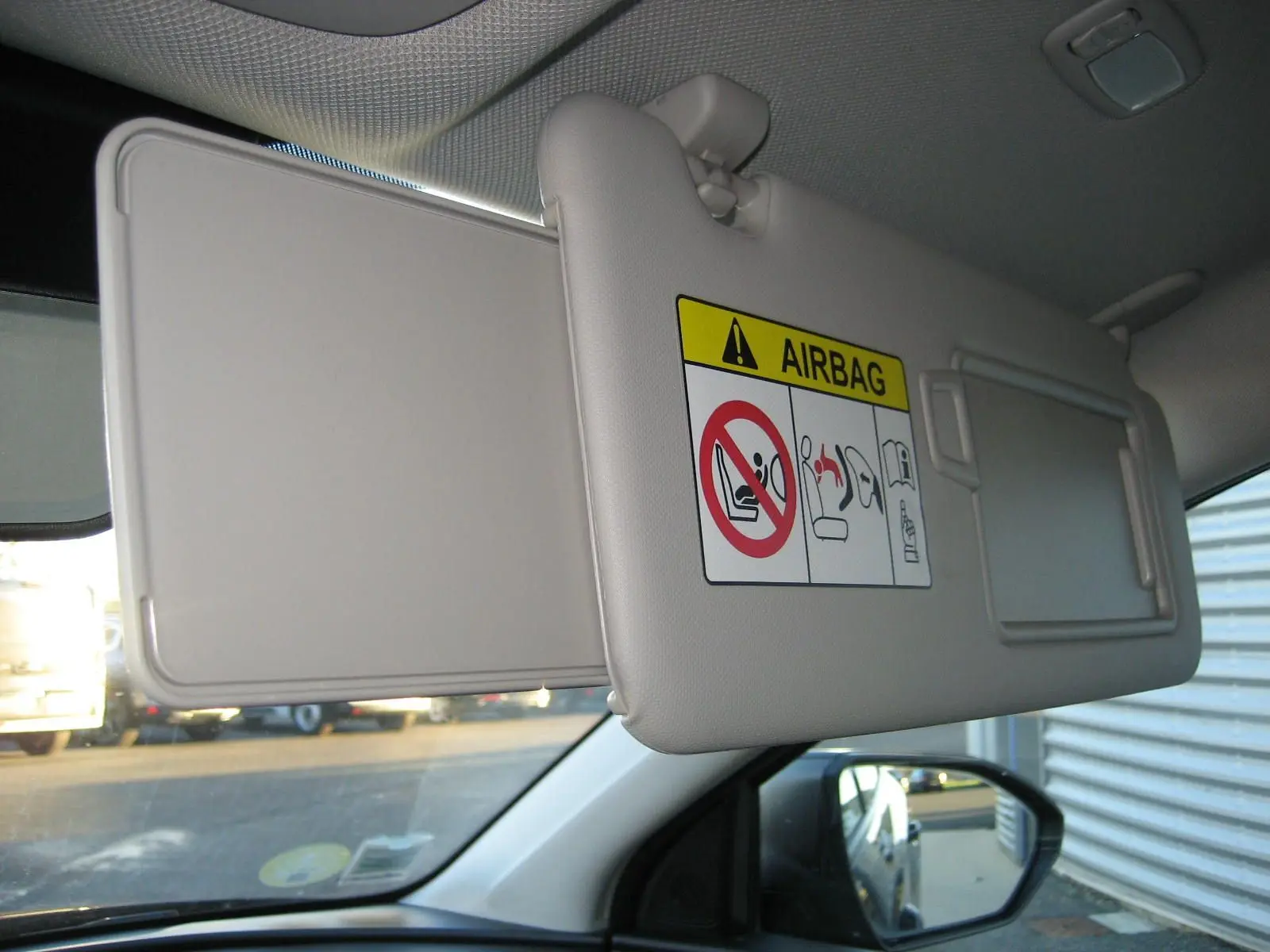 Détail du pare-soleil côté conducteur avec avertissement airbag, intérieur clair du Hyundai Tucson 2022.