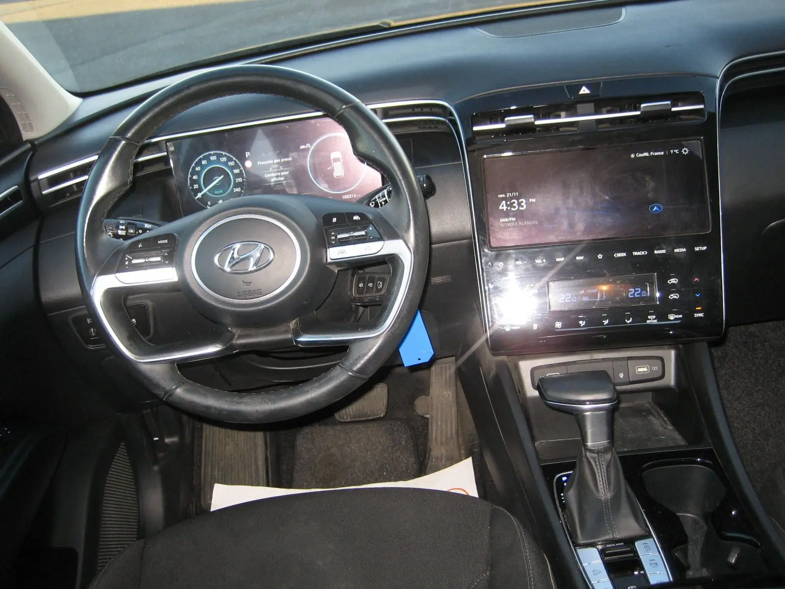 Vue intérieure du tableau de bord et volant noir du Hyundai Tucson III 2022 avec écran tactile et levier de boîte automatique.