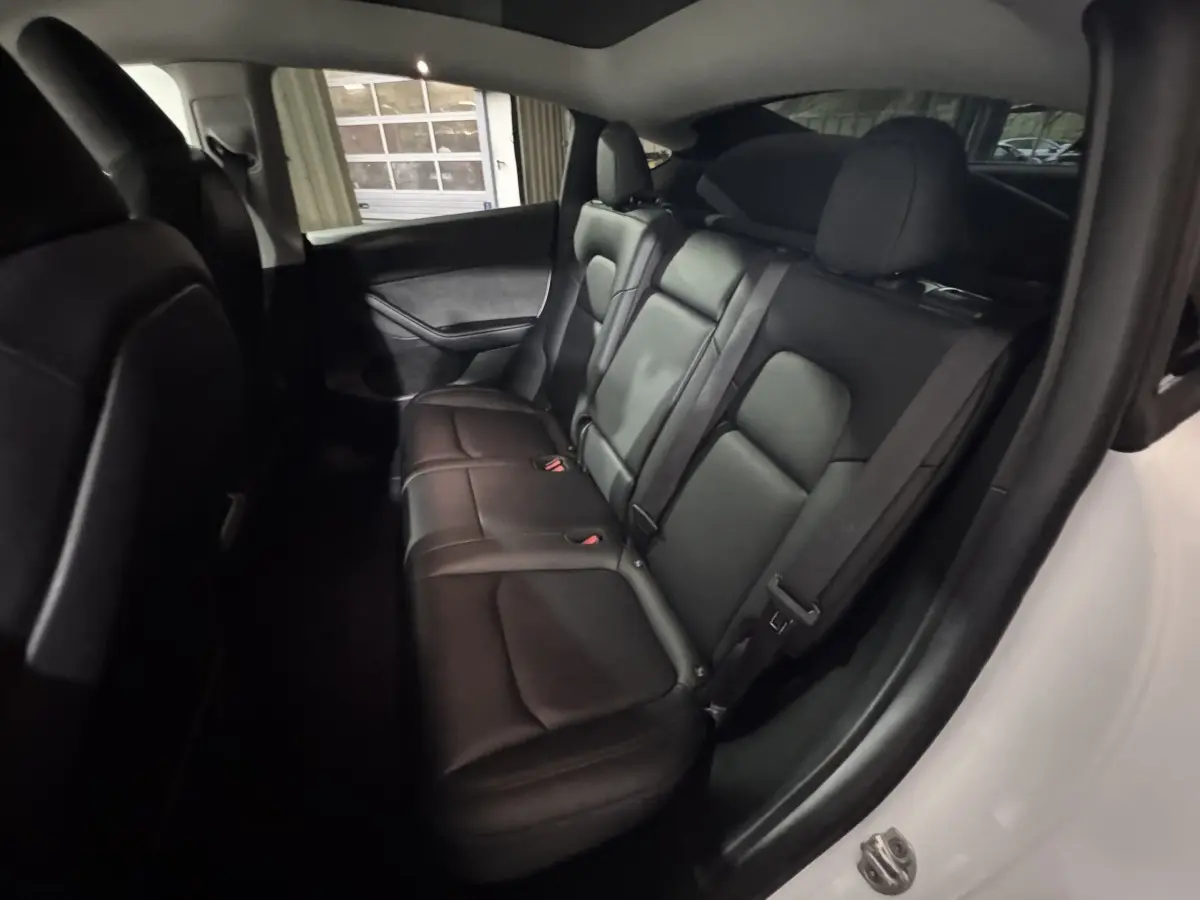 Vue intérieure côté droit sur la banquette arrière en cuir noir du Tesla Model Y blanc 2022 Grand Autonomie.