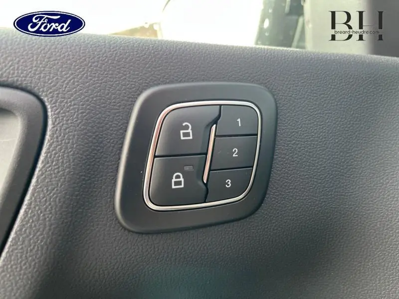 Gros plan sur les boutons de verrouillage et mémorisation des sièges noirs dans un Ford Kuga gris Solar Métallisé 2026.