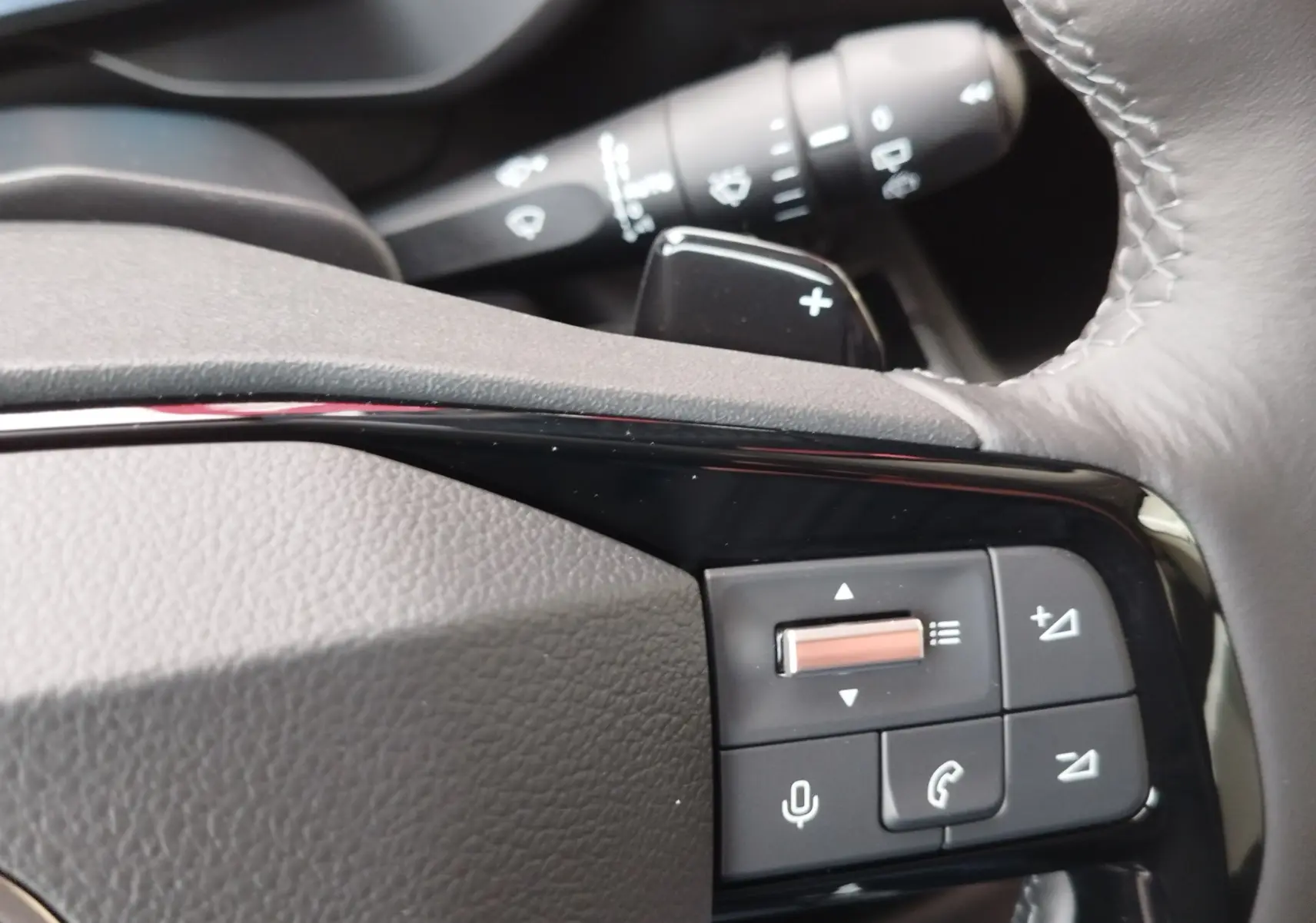 Gros plan sur les commandes au volant gris foncé du Citroën Berlingo 2025, avec molette et boutons multifonctions.