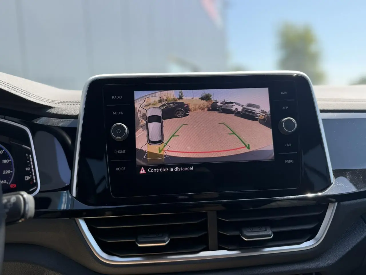 Écran tactile central affichant la caméra de recul du Volkswagen T-Roc 2025 avec alertes de distance.