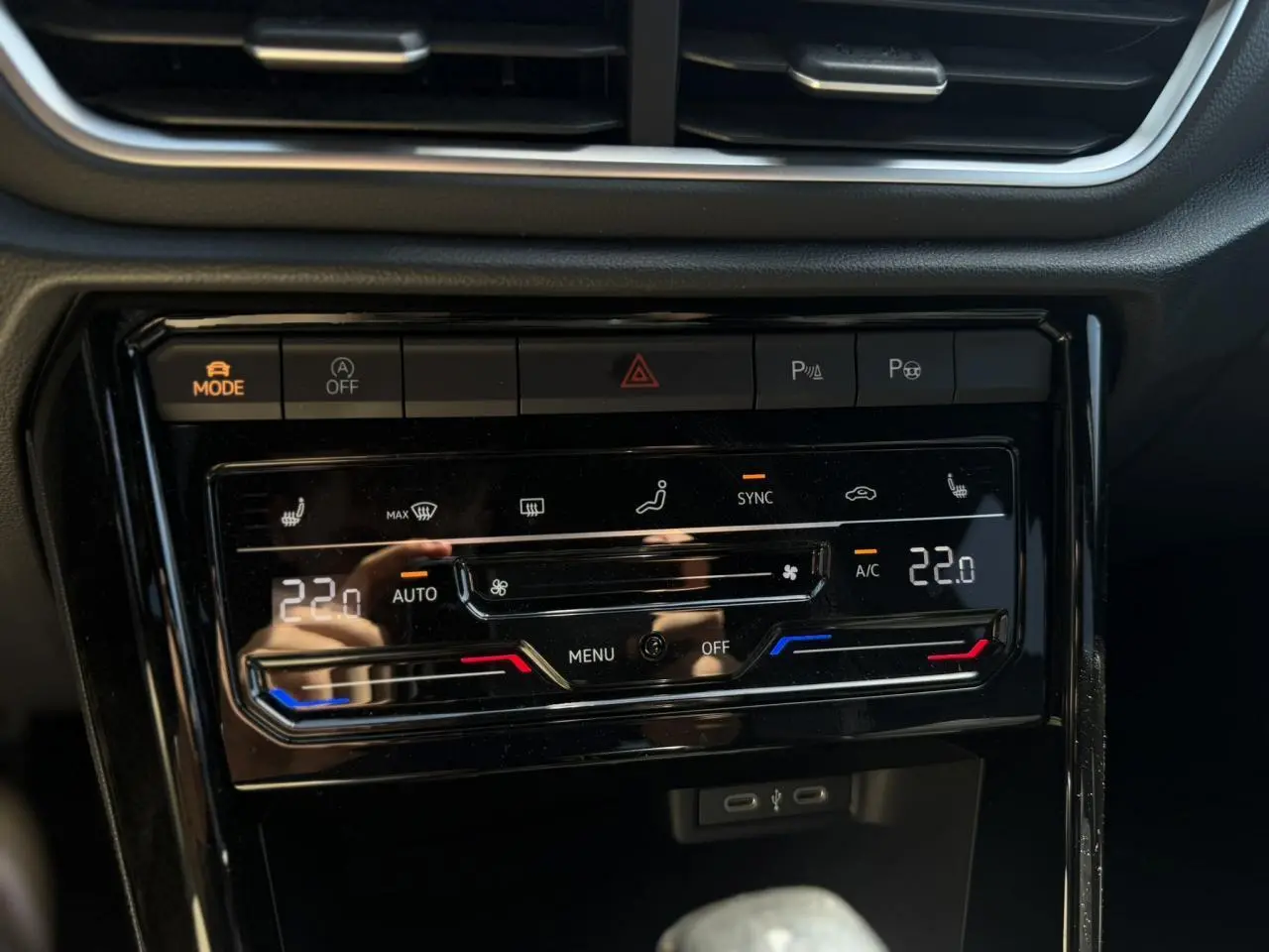 Vue rapprochée de la console centrale du Volkswagen T-Roc 2025, affichant la climatisation automatique bi-zone et ports USB-C.