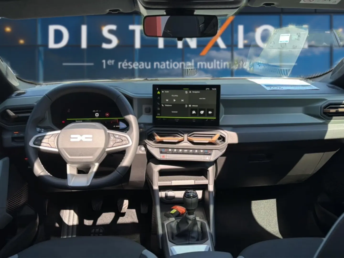 Vue intérieure avant du tableau de bord et volant du Dacia Bigster blanc avec écran tactile et boîte manuelle.