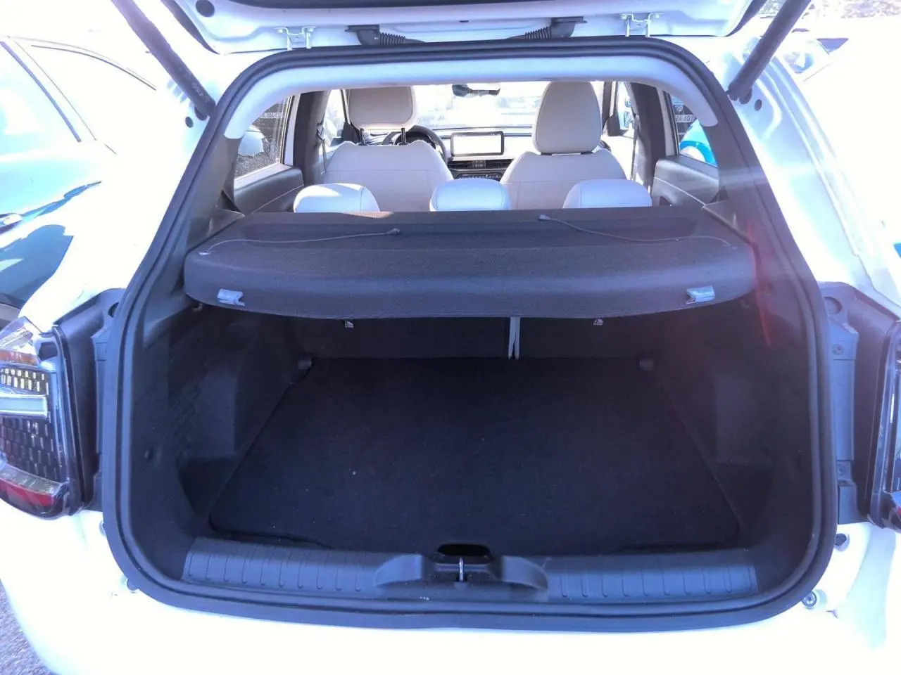 Coffre ouvert vu de l’arrière d’un Fiat 600 blanc 2025, avec cache-bagages et sièges arrière visibles.