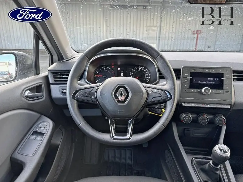 Vue intérieure frontale du volant noir et du tableau de bord de la Renault Clio blanche de 2020 avec boîte manuelle.