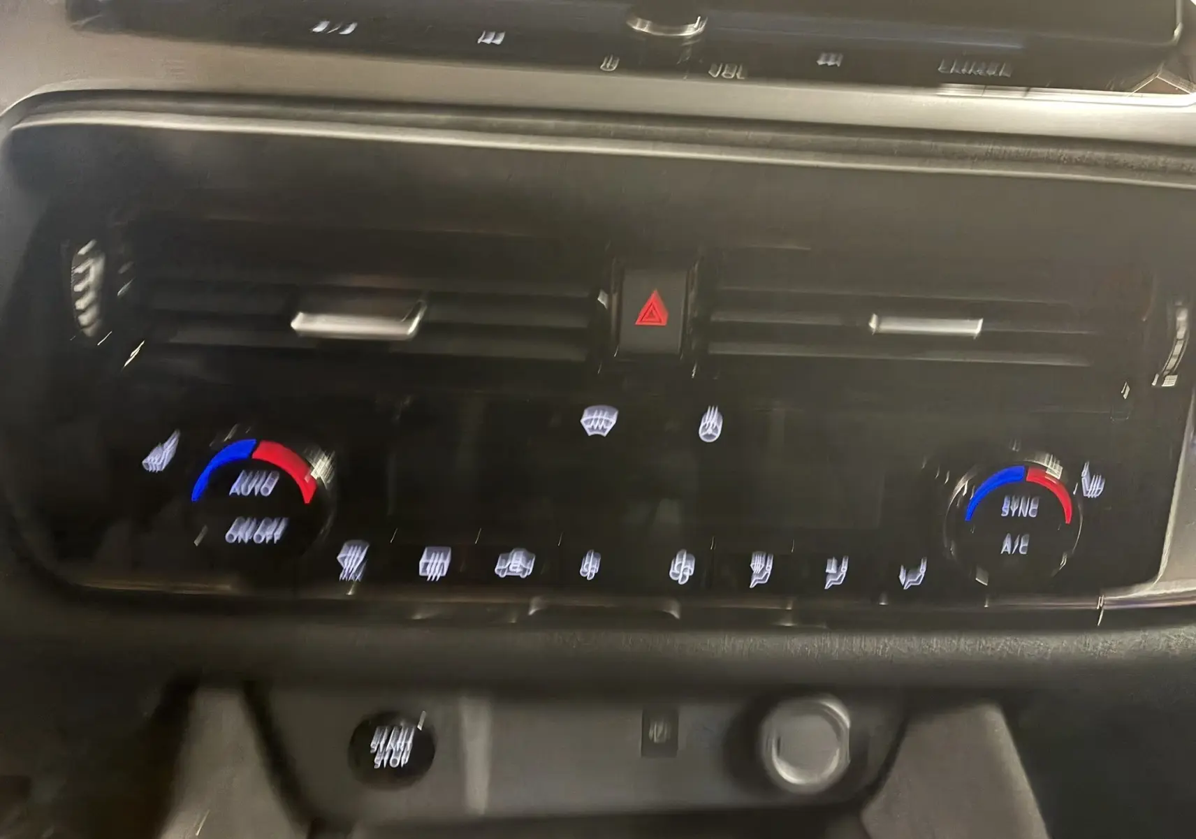 Détail du tableau de bord du Nissan Qashqai 2025 montrant la commande de climatisation automatique avec réglages bleu et rouge.