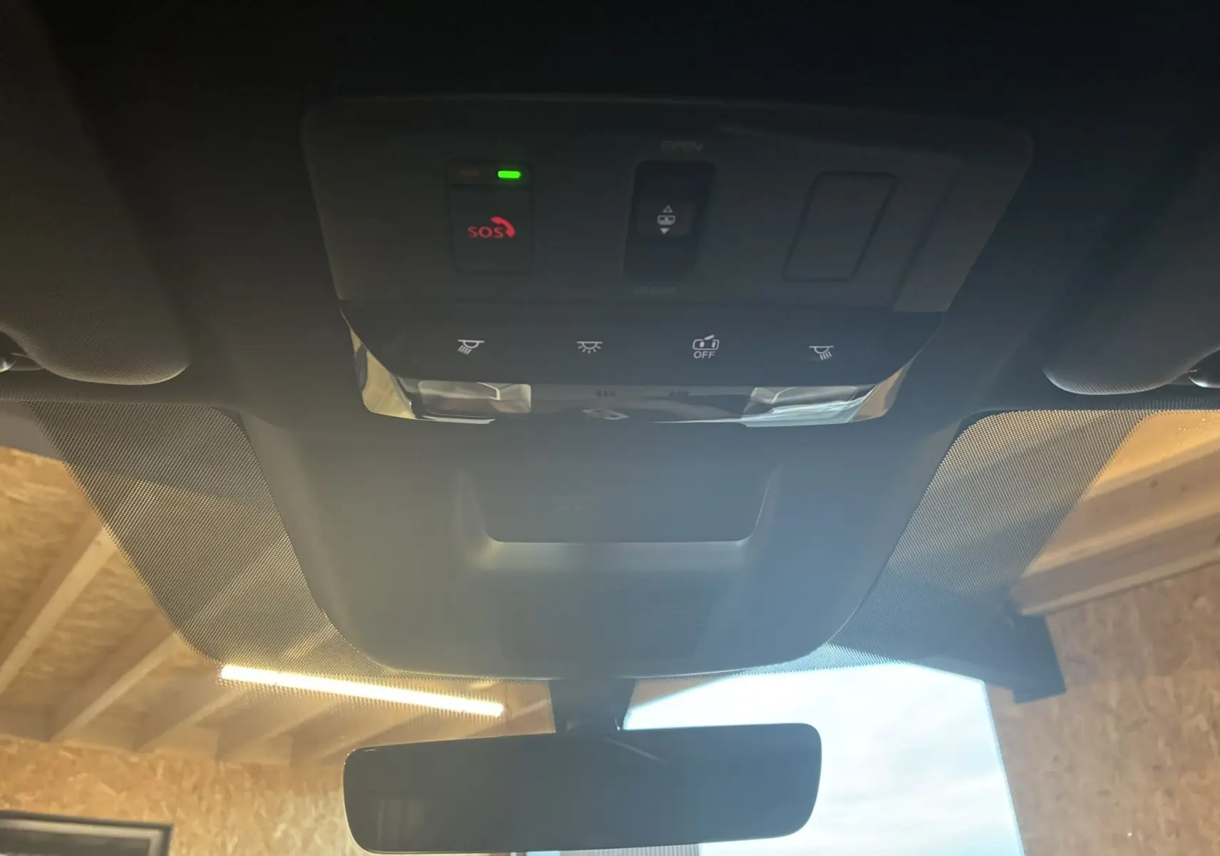 Vue intérieure du toit ouvrant et du panneau de commandes avec bouton SOS du Nissan Qashqai blanc nacré 2025.