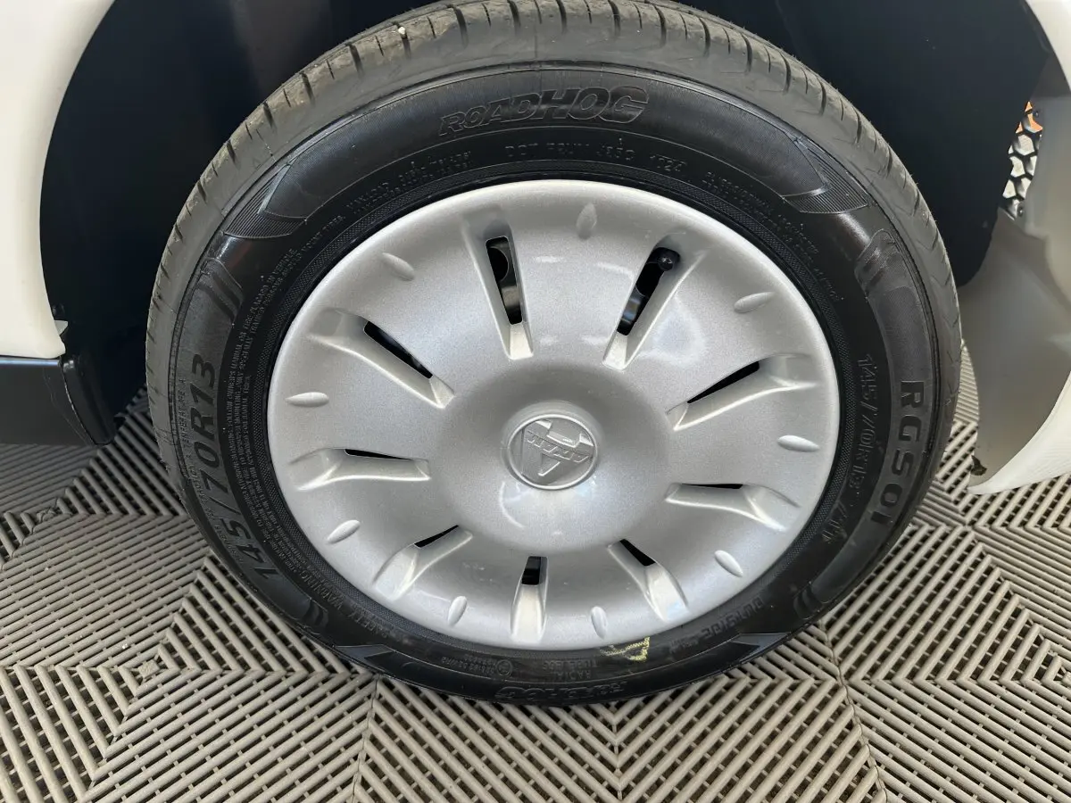 Gros plan sur la roue avant gauche blanche d'une Aixam Ambition E City Pack 2025 avec enjoliveur et pneu Roadhog.