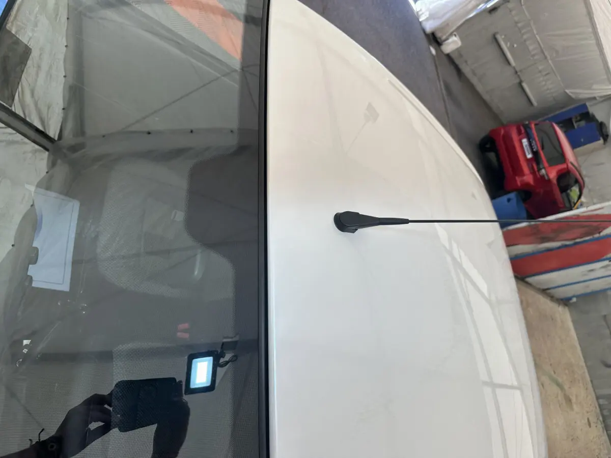 Vue plongeante sur le toit blanc d'une Aixam Ambition E City Pack 2025 avec antenne centrale et intérieur visible.