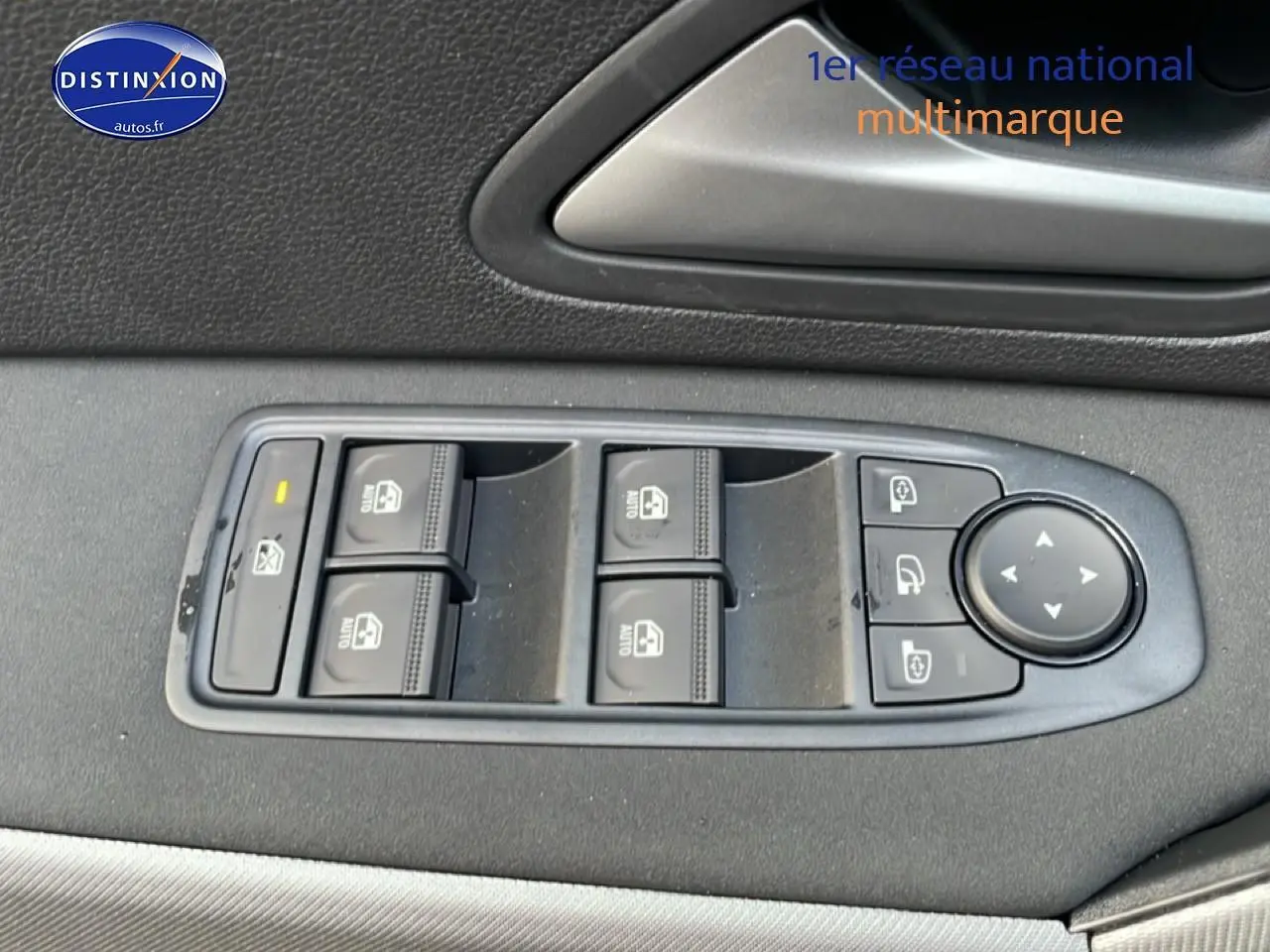 Gros plan sur les commandes des vitres électriques et rétroviseurs sur la porte côté conducteur d'un Dacia Bigster gris schiste.