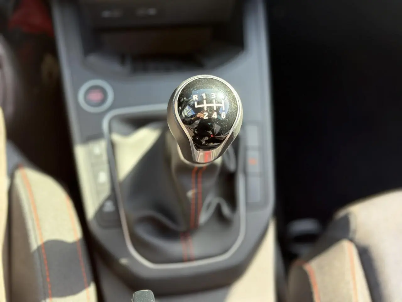 Le levier de vitesses manuel de la SEAT Ibiza TSI 115 FR, vu de dessus avec coutures rouges visibles.