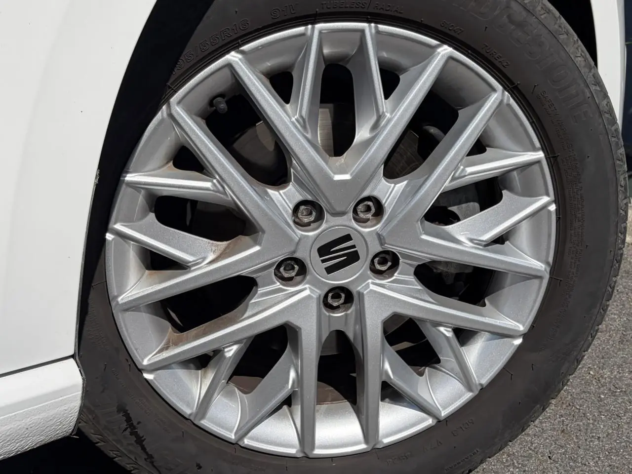 Gros plan sur la jante alliage 16'' argentée d'une SEAT Ibiza blanche Candy, côté gauche avant.