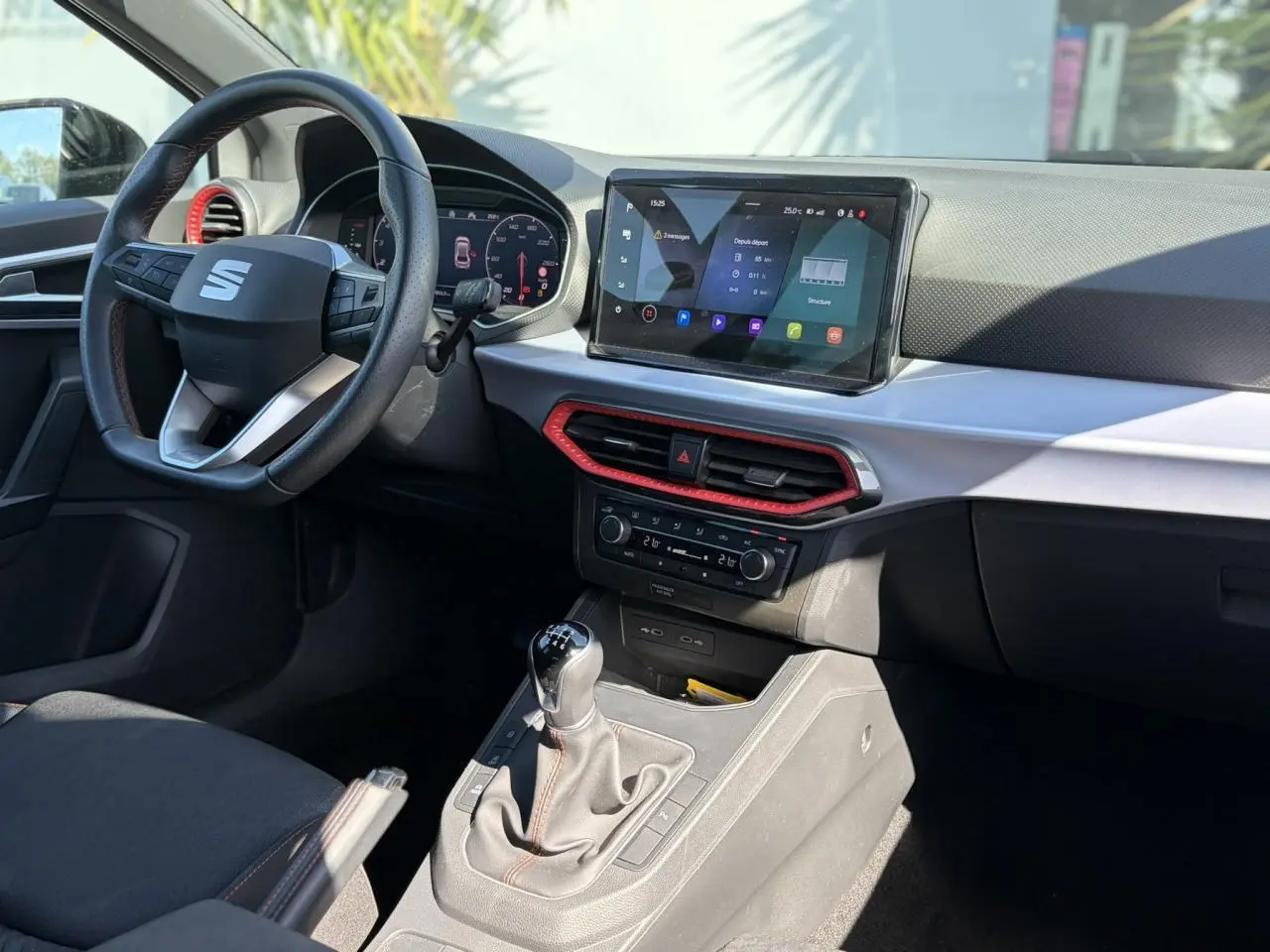 Vue intérieure côté conducteur du tableau de bord et console centrale d'une SEAT IBIZA TSI 115 FR avec détails rouges et écran tactile.