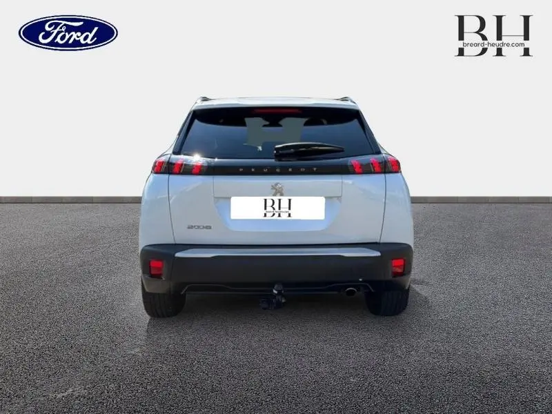Vue arrière d'un Peugeot 2008 blanc nacré 2022 avec attelage rotule démontable et feux arrière LED distinctifs.